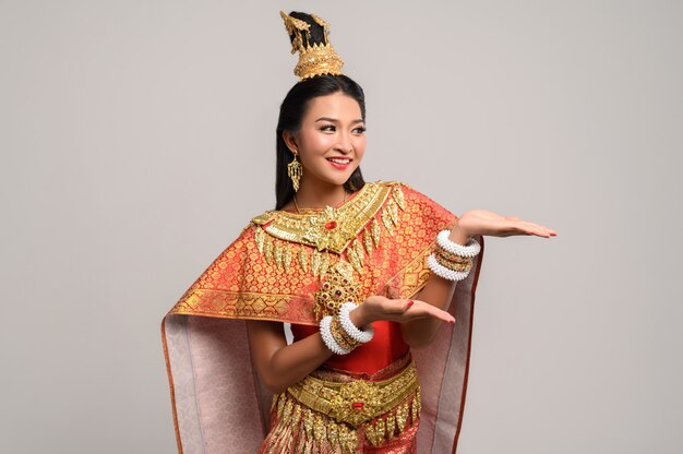 Красивая тайская женщина нося тайское платье и счастливую улыбку.