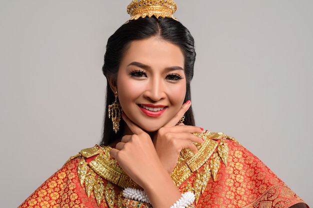Foto gratuita bella donna tailandese che indossa un abito tailandese e un sorriso felice.