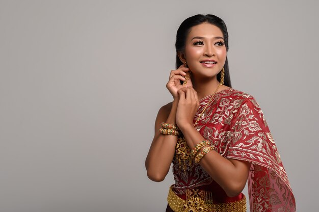 Beautiful Thai woman wearing Thai dress and looking at the top