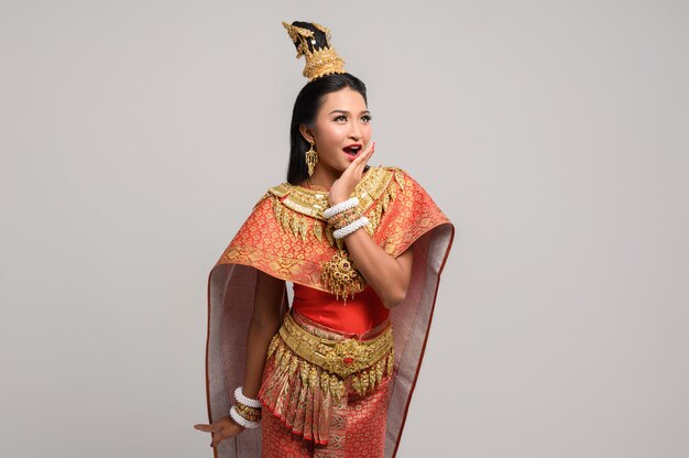 Красивая тайская женщина, носящая тайское платье и смотрящая наверх