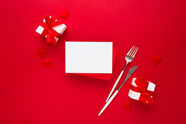 Beautiful top view of empty greeting card for Valentines on red