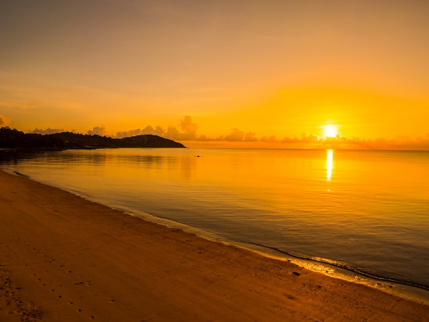 日の出や日没の時間で雲と空と美しい熱帯のビーチと海の海の風景