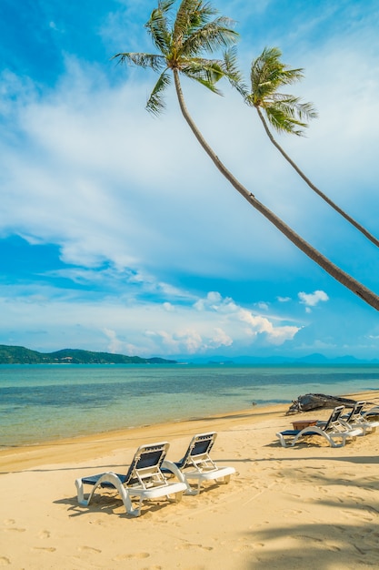 美しい熱帯のビーチとヤシの木とパラダイス島の椅子と海