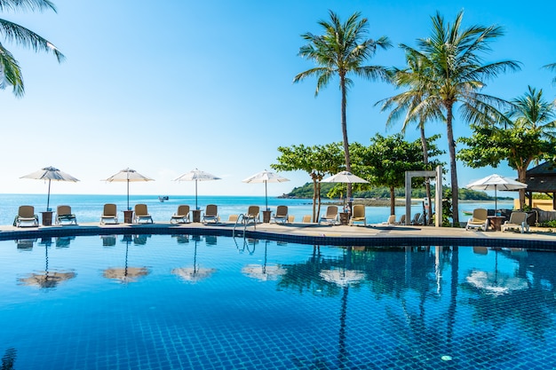 Foto gratuita bellissima spiaggia tropicale e mare con ombrellone e sdraio in piscina
