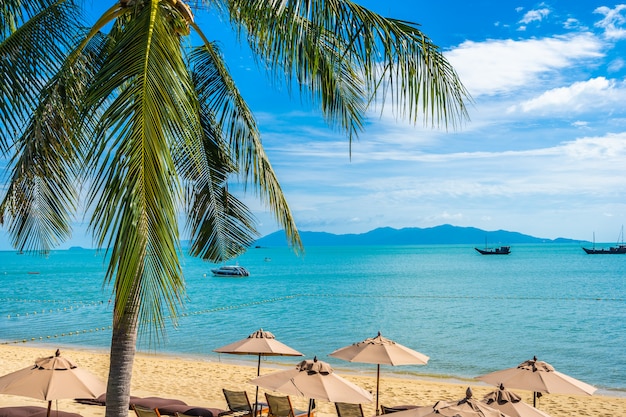 Beautiful tropical beach with coconut tree and umbrellas