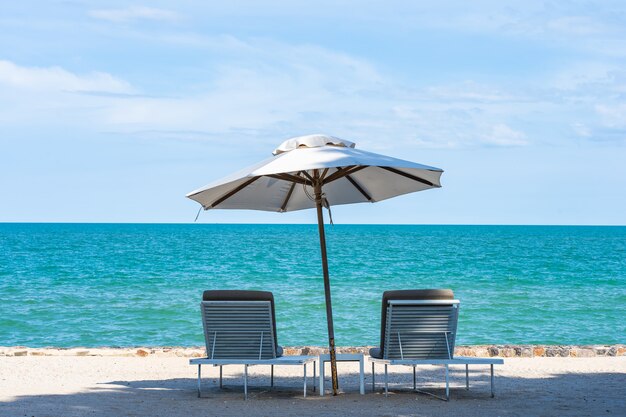 旅行のための青い空とビーチ海海の周りの美しい傘と椅子