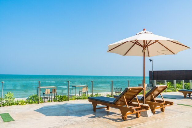 Beautiful umbrella and chair around swimming pool in hotel and resort