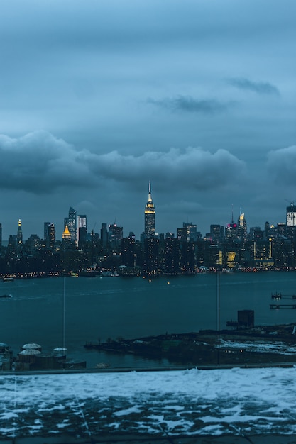 Foto gratuita bella città urbana con incredibili nuvole nel cielo sullo sfondo