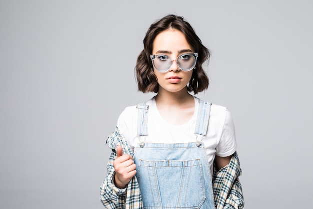 Beautiful urban woman wearing trendy sunglasses and sweater over shoulders, posing for advertising or promotion