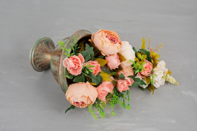 Beautiful vase of pink roses on grey table.