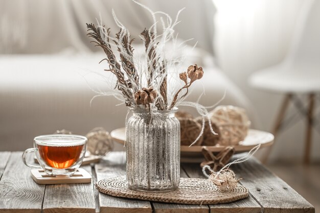 Beautiful vase with flowers and a cup of tea