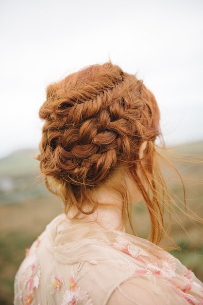 Beautiful vertical picture of braided hair of a ginger female