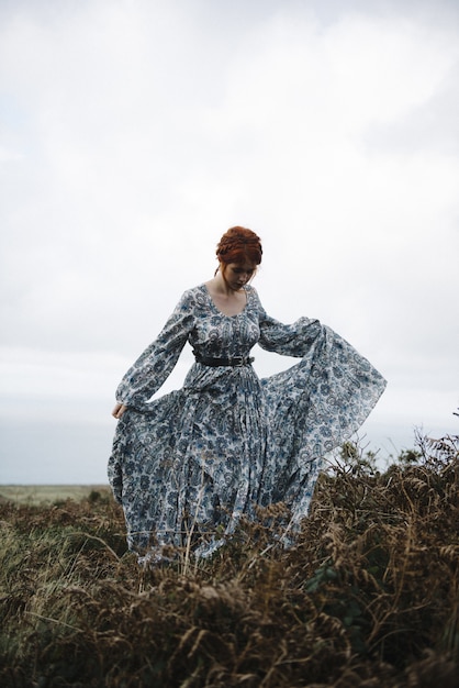 Free photo beautiful vertical picture of a ginger female with a pure white skin in a light blue gown