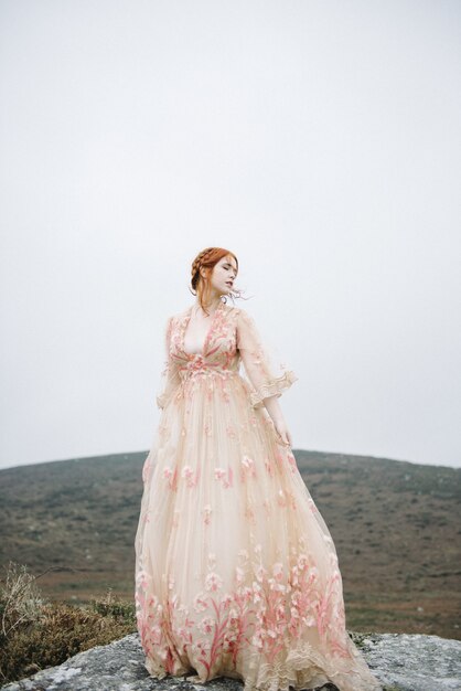 Free photo beautiful vertical shot of a ginger female with a pure white skin in a pink gown