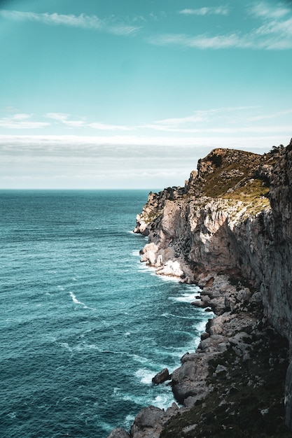 Beautiful vertical view of rocky seashore and the blue calm sea