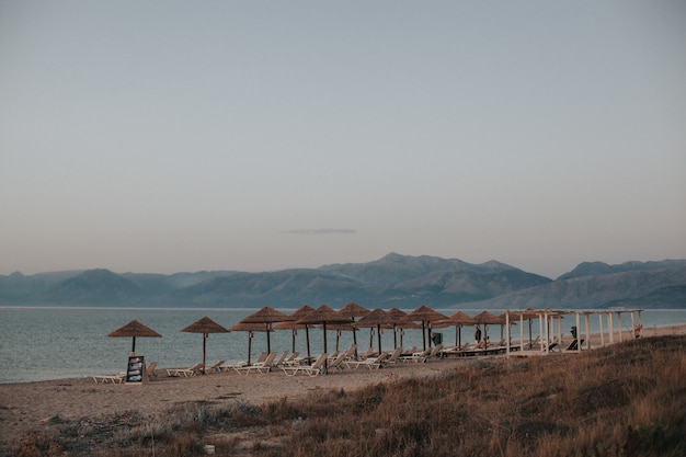 Beautiful view of a beach with deck chairs under straw beach umbrellas