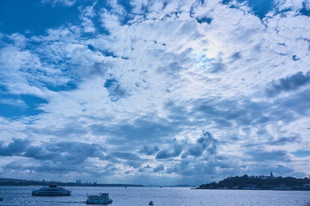 Прекрасный вид на голубое небо с белыми облаками, море с лодками и город Стамбул на линии горизонта