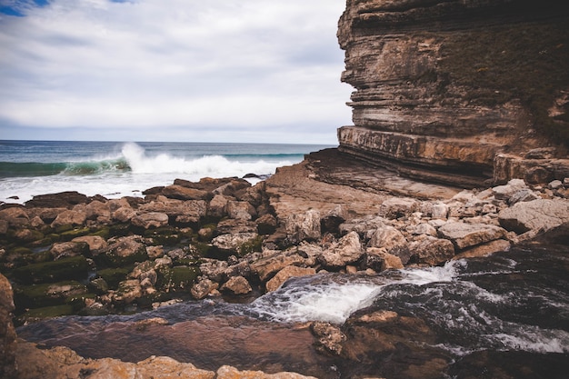 Free photo beautiful view foamed wave in the coast  near the cliff