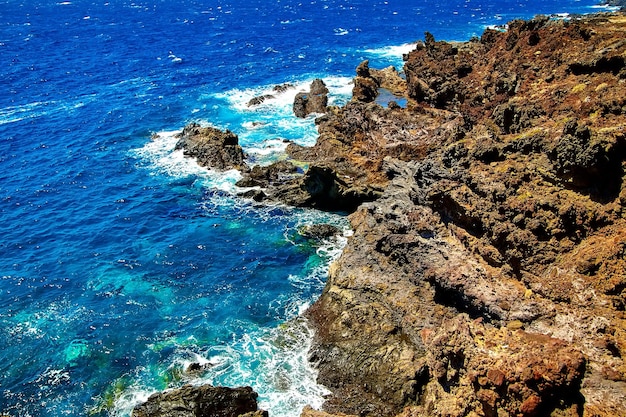 Beautiful view from the cliff of mountain to the ocean with blue sky and clouds