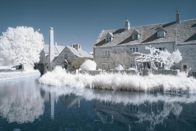 雪の降る冬の日に木々に囲まれた家々の美しい景色