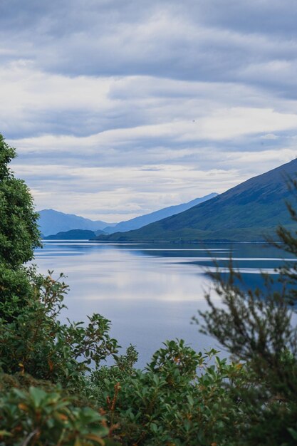 Beautiful view of the mountain chain covered in snow and a lake on a cloudy day