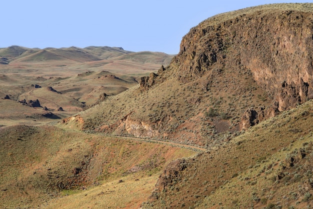 Beautiful view of a pathway on the side of the mountain with hills and a blue sky in background