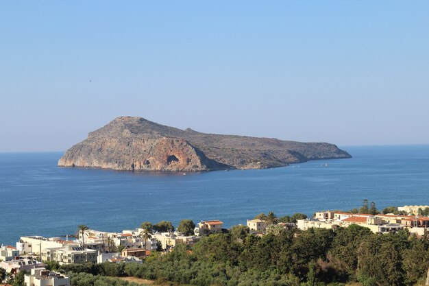 Beautiful view of the Platanias village in Crete, Greece full of trees and building near the shore