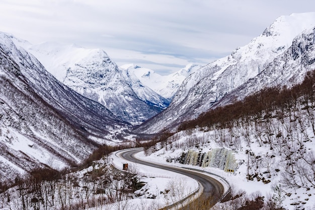 ノルウェーの雪をかぶった山々に囲まれた道路の美しい景色