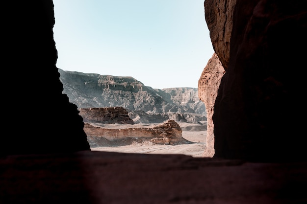 Beautiful view of the rocks and cliff in a desert captured from inside a cave