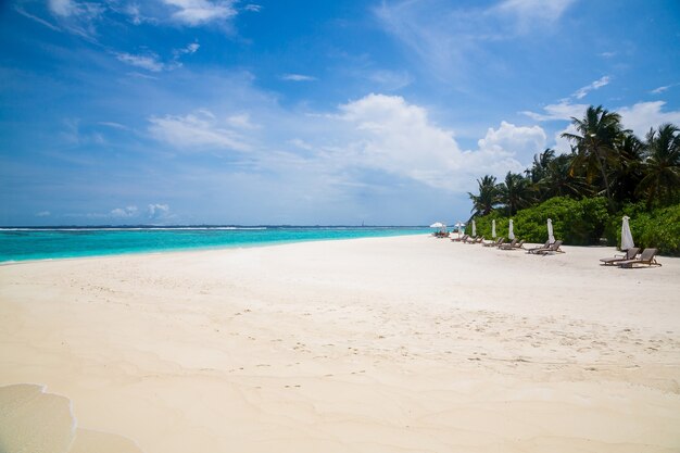 Beautiful view of the wavy ocean hitting the sandy beach under the cloudy sky