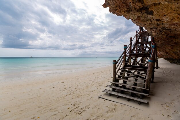 Beautiful view of a wooden stairway on the beach by the ocean captured in Zanzibar, Africa