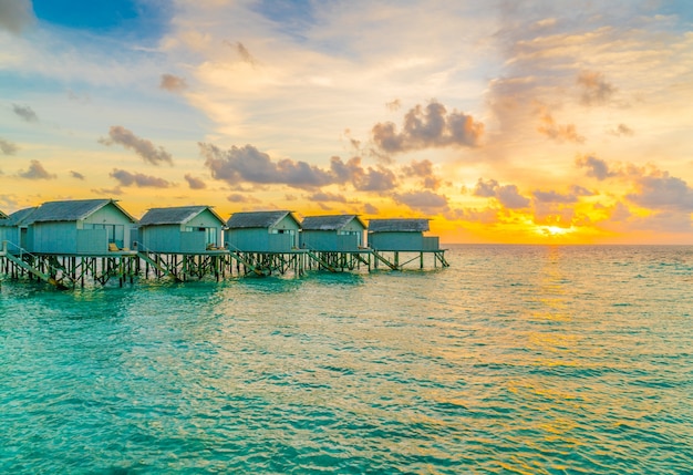 Beautiful water villas in tropical Maldives island at the sunset time