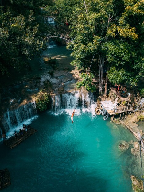 Beautiful waterfall streaming down into the river surrounded by greens