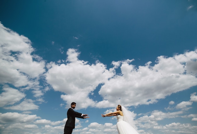 Beautiful wedding couple on the background of blue sky