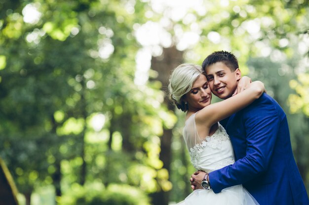 Beautiful wedding couple hugging in the park