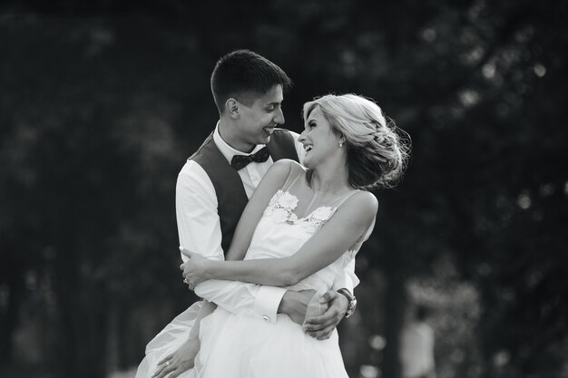 Beautiful wedding couple hugging in the park
