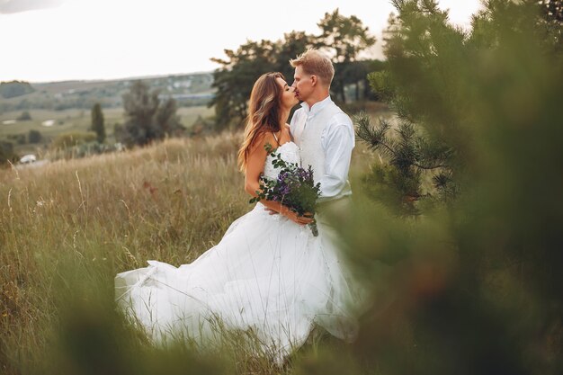 Beautiful wedding couple in a summer field