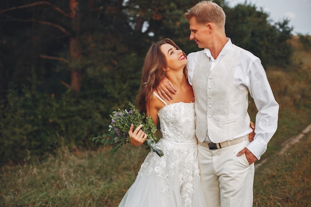 Beautiful wedding couple in a summer field