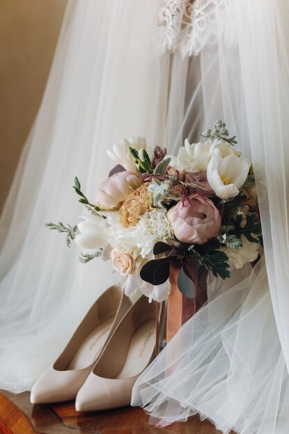 美しい結婚式の靴、ドレス、花の花束
