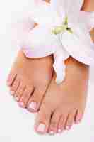 Free photo beautiful wellgroomed female feet with flower