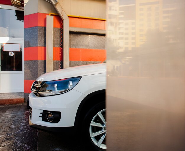 Beautiful white car exiting car wash