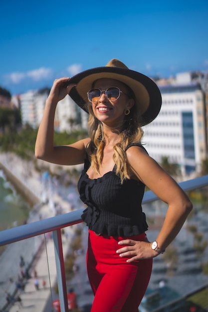 Foto gratuita bella donna caucasica bianca felicemente in piedi sul balcone con vista sul mare