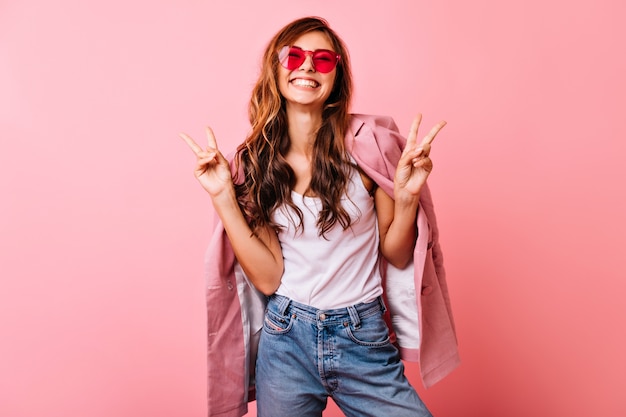 Foto gratuita bella ragazza bianca con lunghi capelli ondulati in posa con eccitazione. ritratto dell'interno della donna ottimista dello zenzero che scherza sul rosa.