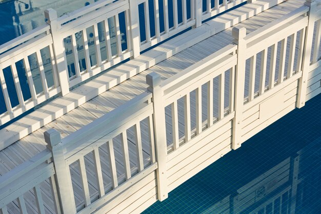 Beautiful white wooden bridge across the water in the sun