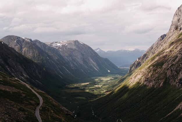 Beautiful wide shot of mountains facing each other covered with green grass