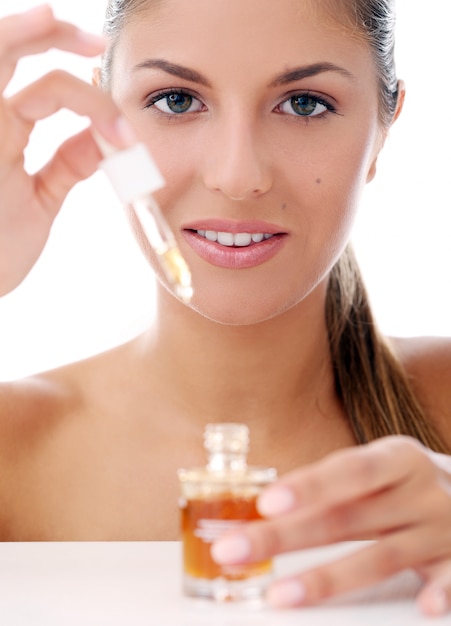 Beautiful woman applying cosmetics