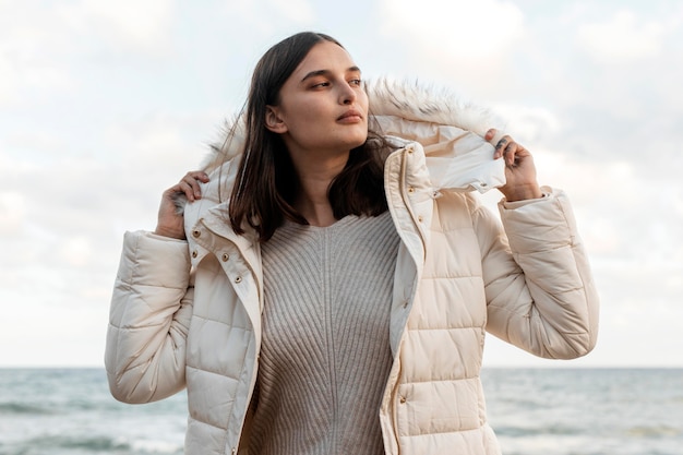 Beautiful woman at the beach with winter jacket