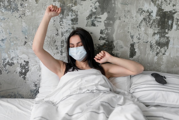 Beautiful woman in bed with face mask on