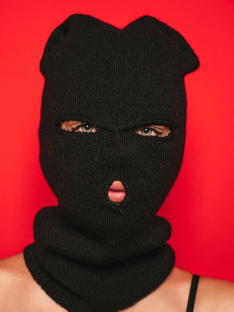 Beautiful woman in black swimwear bathing suit. Model wearing bandit balaclava mask.