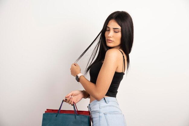 Beautiful woman in black top posing with shopping bags. High quality photo